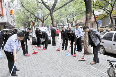 河南信阳市政执法人员上街大扫除 十余人扫一小块