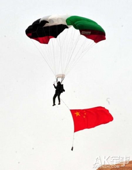 资料图：5月5日，在约旦首都安曼阿卜杜拉国王特战训练中心，一名中国参赛队员携五星红旗跳伞着陆。