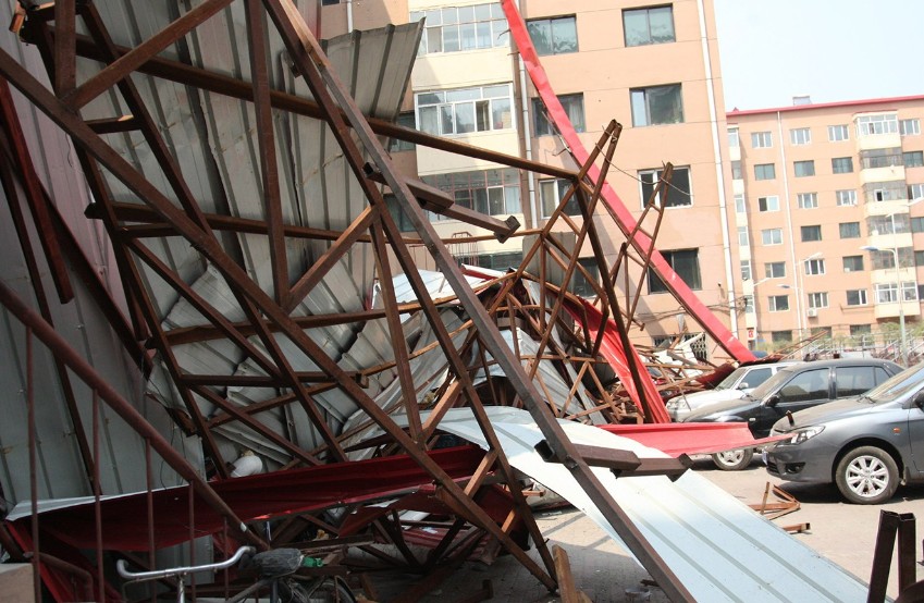 哈尔滨一楼房房盖被大风吹落 近十辆车被砸