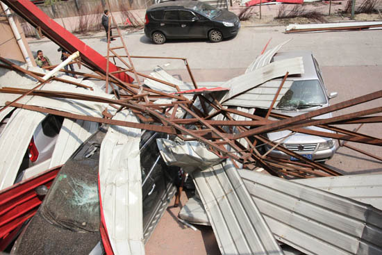 哈尔滨一楼房房盖被大风吹落 近十车被砸