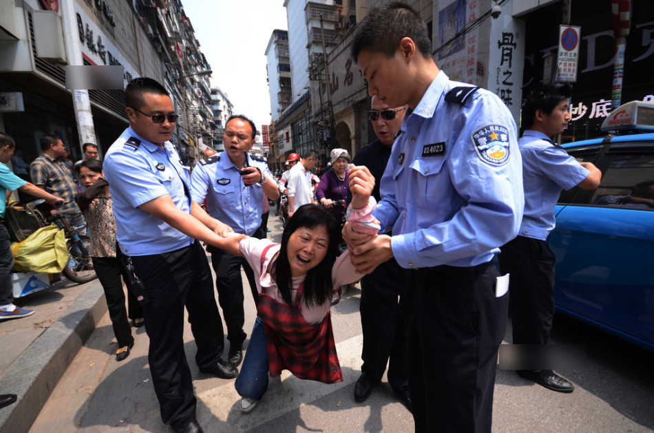 南昌摊贩躺车下拦交警拖车