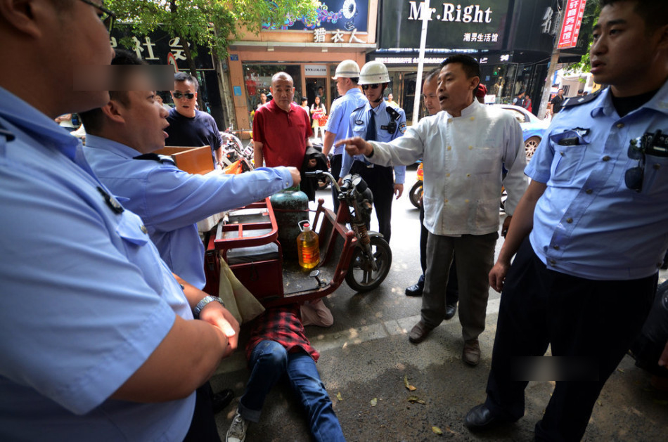 南昌摊贩躺车下拦交警拖车