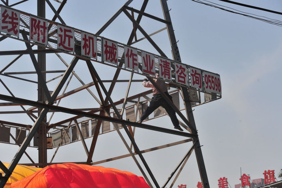 北京男子爬高压线塔挂条幅 不慎失足坠落