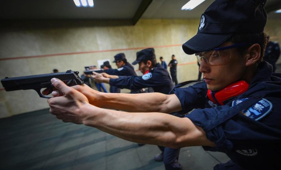 图为特警队员进行持枪战术队形训练。
