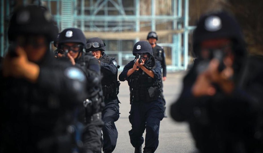图为特警队员进行持枪战术队形训练。