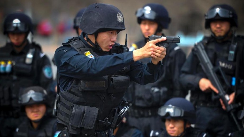 图为特警队员进行持枪战术队形训练。