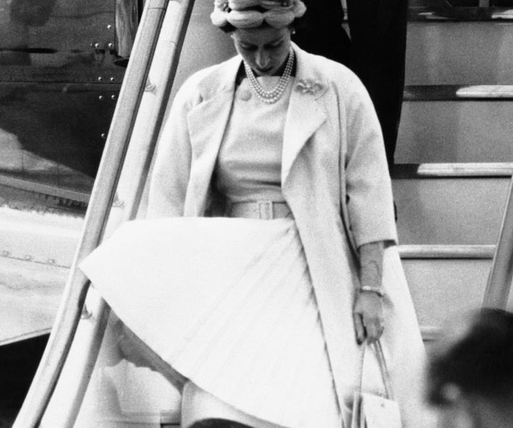 1959年8月，伦敦，英国女王伊丽莎白二世裙子被风吹起，那个年代，裙子里普遍都有里衬。