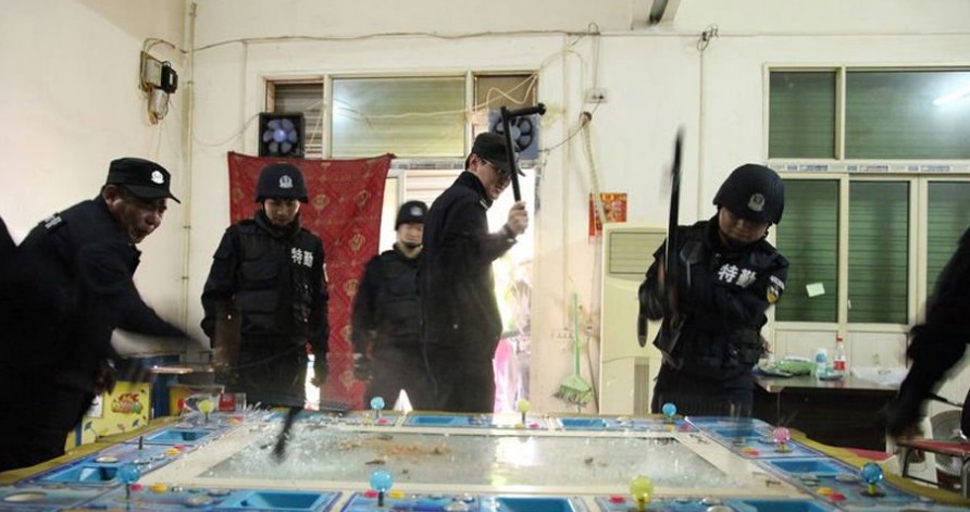 图为警方砸毁游戏机。