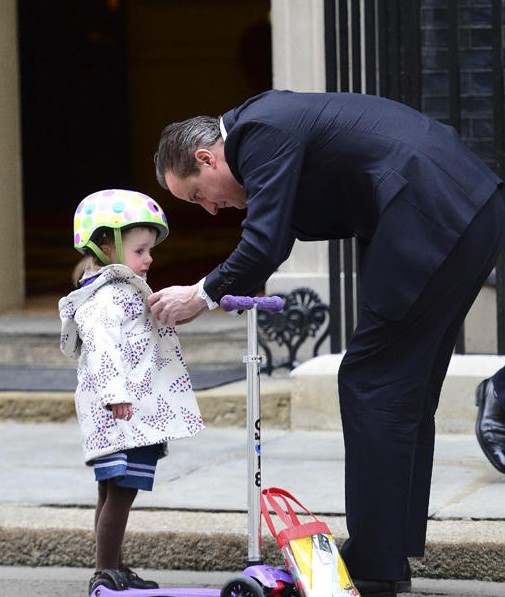 英国首相卡梅伦驮女儿上幼儿园