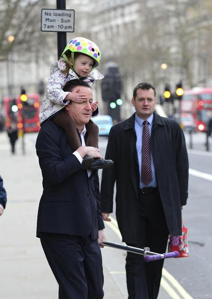 英国首相卡梅伦驮女儿上幼儿园