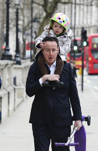 英国首相卡梅伦驮女儿上幼儿园