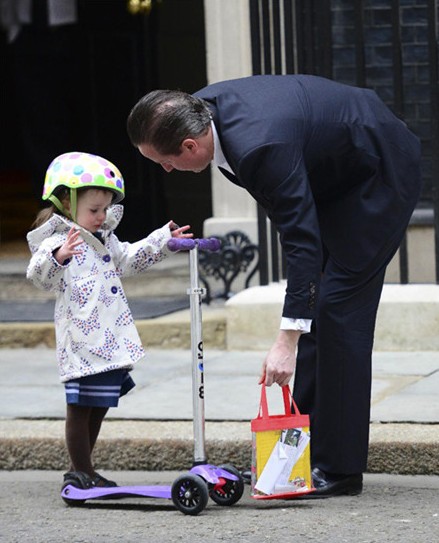 英国首相卡梅伦驮女儿上幼儿园