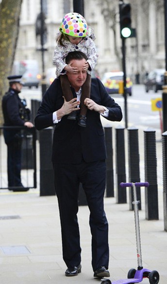 英国首相卡梅伦驮女儿上幼儿园