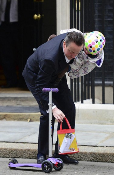 英国首相卡梅伦驮女儿上幼儿园