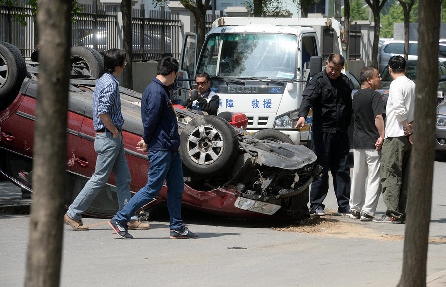 北京一女子驾车失控 连撞八车后翻倒路中