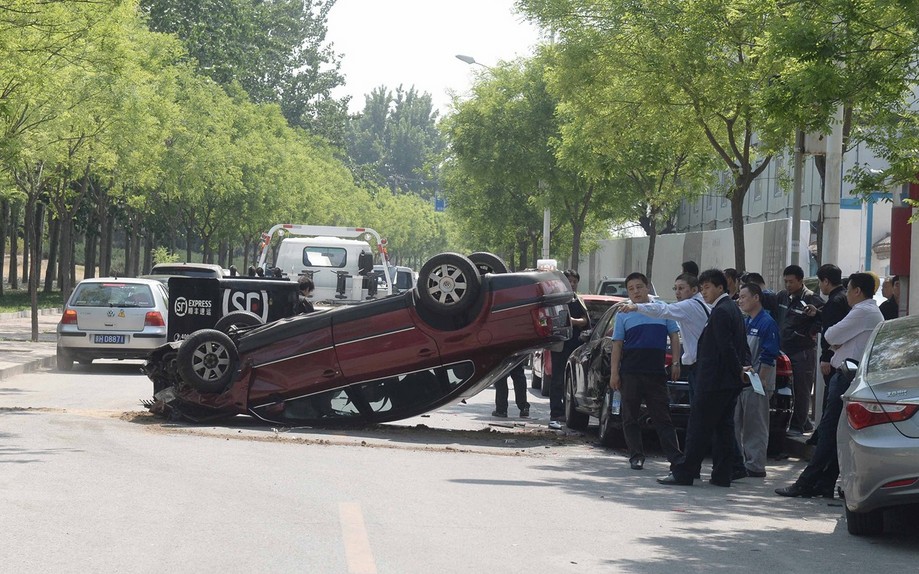 北京一女子驾车失控 连撞八车后翻倒路中