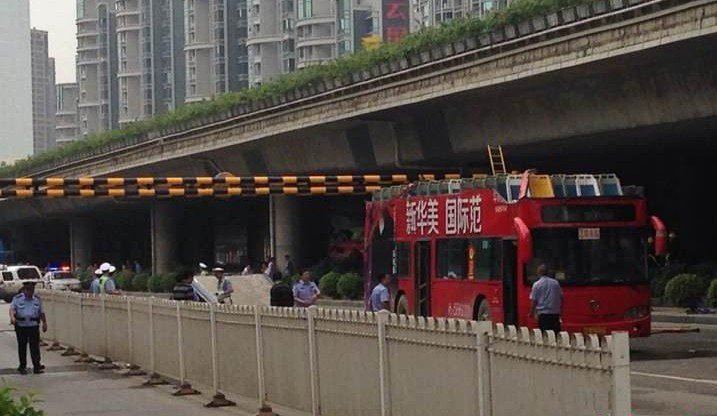 双层公交车撞上限高框被“削顶”