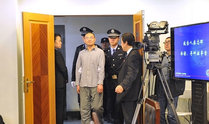 8时58分，身着便装的被告人秦志晖被法警带入法庭。